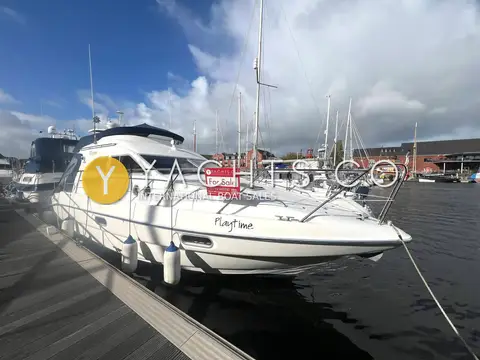 Sealine International F33: starboard bow view of the hull and flybridge on a pontoon under cloudy sky