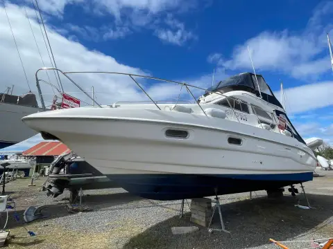 Sealine International F33: port side of the hull ashore with blue antifouling, bow rail and flybridge