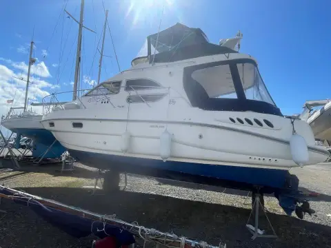 Sealine International F33: starboard side of the hull ashore under bright sun, flybridge canopy fitted