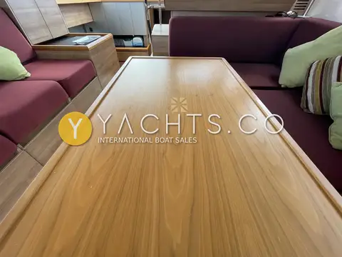 Sealine International F42: close view of walnut saloon table with inlaid compass rose and plum seating