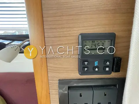 Sealine International F42: diesel heating control panel on walnut bulkhead above twin mains sockets