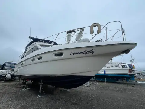 Sealine International F43: port bow view ashore in a boatyard showing dark blue antifouled hull