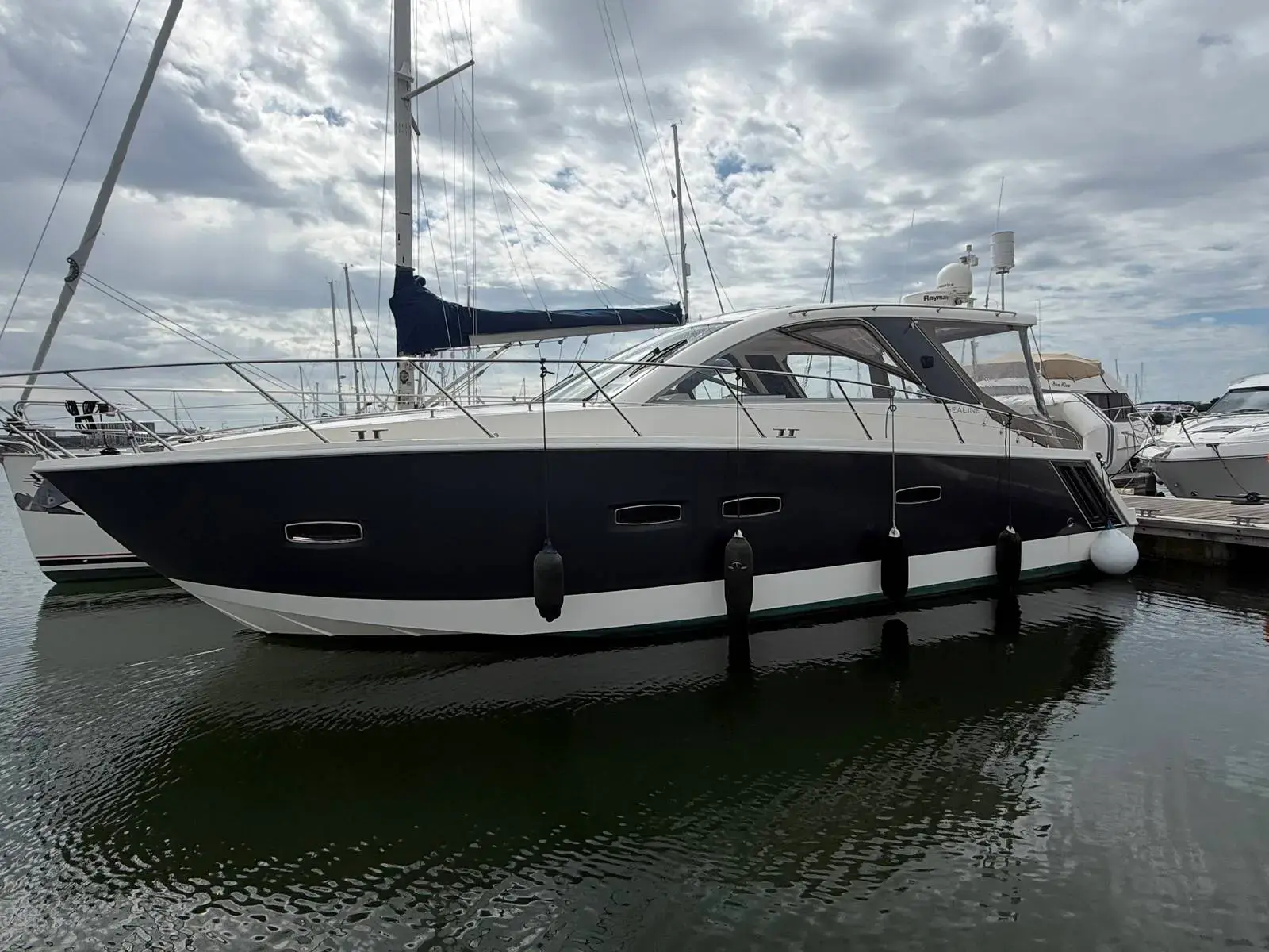 Sealine International SC35: port side view of the grey-wrapped hull and white superstructure moored at a marina pontoon