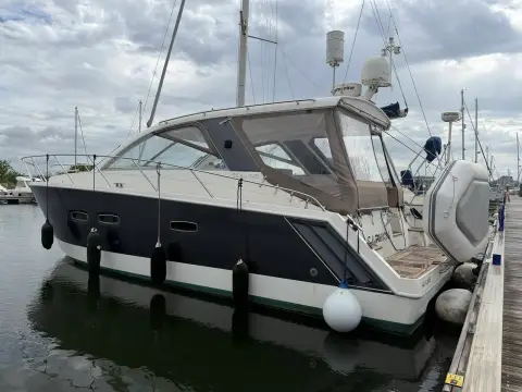Sealine International SC35: starboard quarter showing grey hull wrap, hull windows and swim platform alongside a pontoon