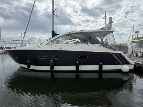 Sealine International SC35: starboard side profile with grey hull, fenders out and glazed hardtop under cloudy sky