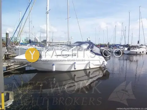 Sealine International Sealine 270 Reduced: port side view moored in marina with navy canopy fitted and yachts behind