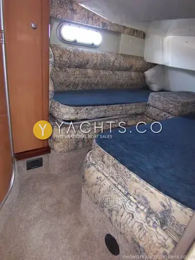 Sealine International Sealine 360 Statesman: twin berth cabin with patterned upholstery, blue cushions and an opening porthole