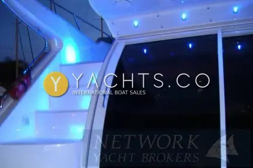 Sealine International Sealine 410 Aft Cabin: cockpit steps to the flybridge lit by blue LED lights at night, beside the saloon sliding door