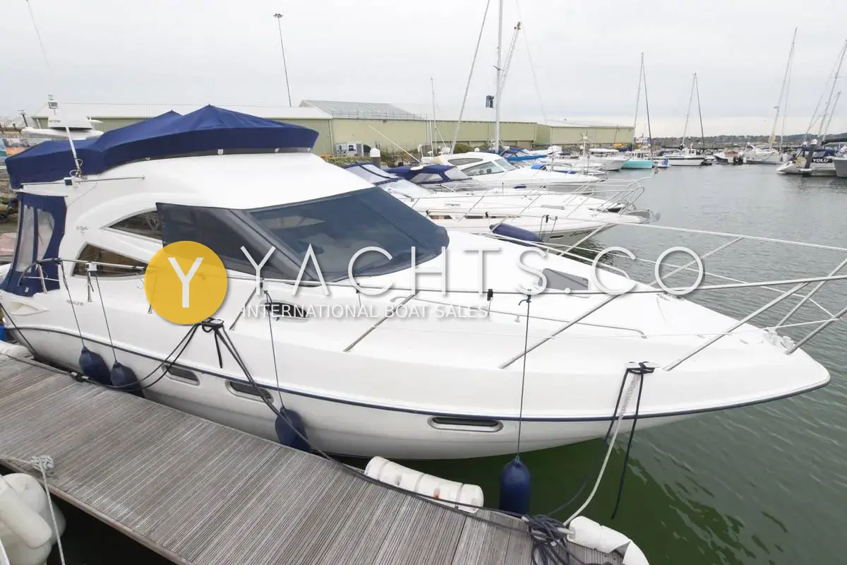 Sealine International Sealine F34: white flybridge hull seen from the bow, moored alongside a pontoon in a marina