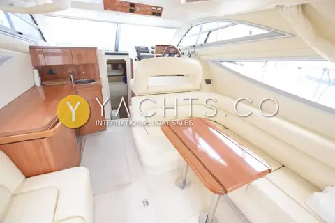 Sealine International Sealine F34: saloon with cream leather seating, gloss wood table and galley units to port