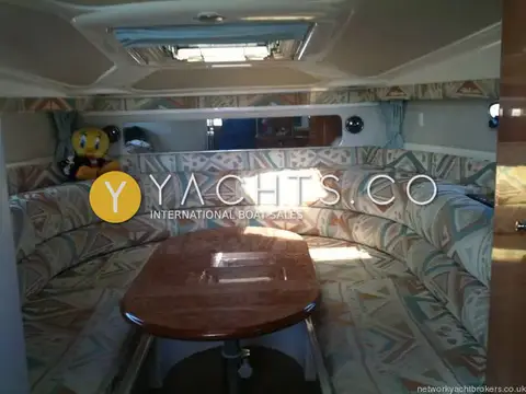 Sealine International Sealine S28 Reduced: saloon dinette with geometric patterned upholstery, wooden table and mirrored bulkhead