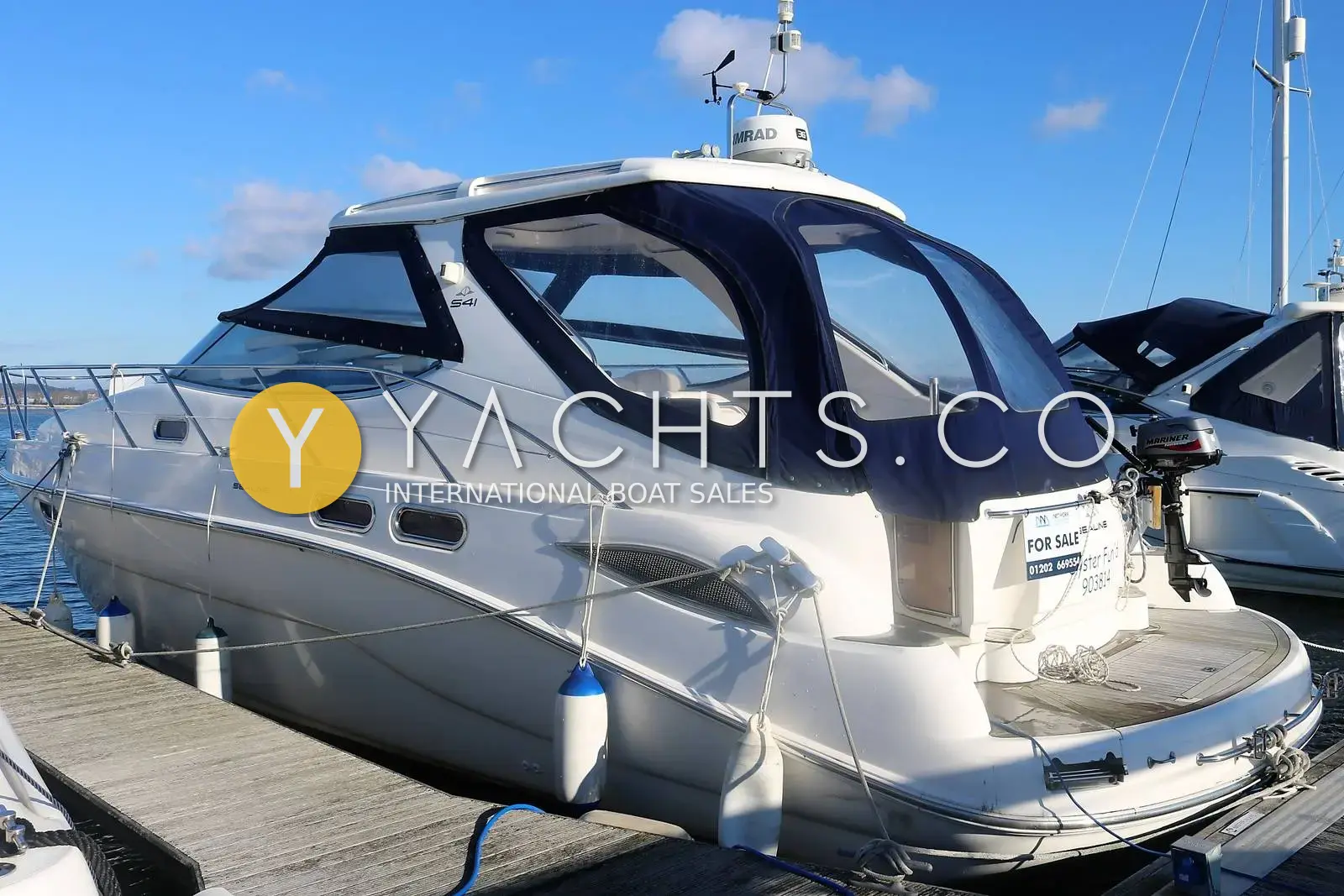Sealine International Sealine S41: starboard quarter view moored at a pontoon, navy canopy fitted and outboard on the stern