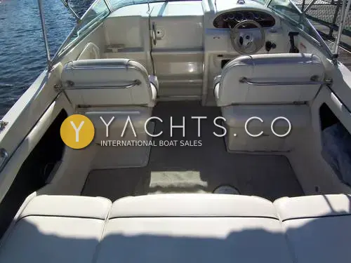 Sea Ray 215 Express Cruiser: cockpit looking forward from the aft bench to twin helm seats and carpeted floor