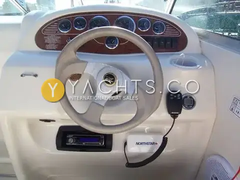 Sea Ray 215 Express Cruiser: helm with wood-grain dash, gauges, steering wheel, stereo and handheld radio microphone
