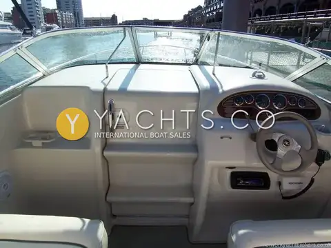 Sea Ray 215 Express Cruiser: wraparound windscreen, cabin entry door with steps, and helm console seen from the cockpit
