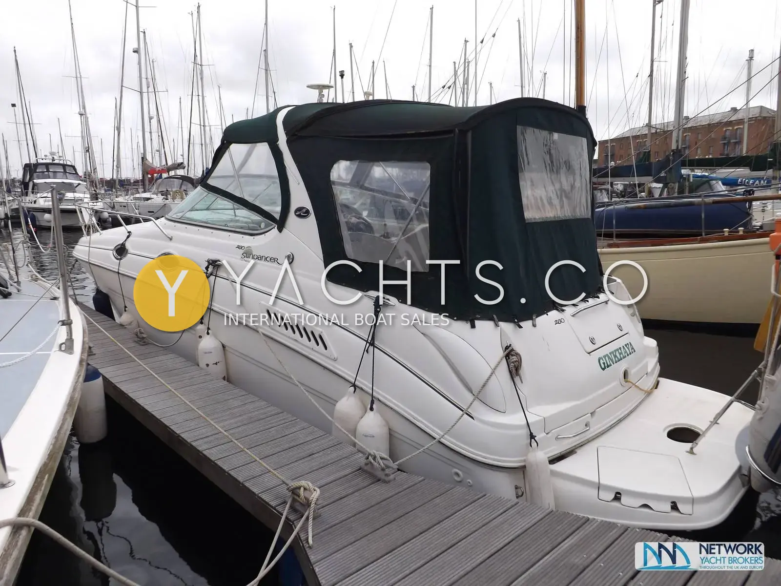 Sea Ray Sundancer 280: white hull afloat alongside a pontoon with dark blue canopy fitted over the cockpit