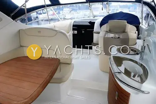 Sessa Marine Sessa C30: cockpit with cream seating, teak table, helm seats and wet bar under navy canopy