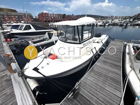 Smartliner 21 Fisher: bow view of the boat alongside a wooden pontoon with fenders out and marina behind