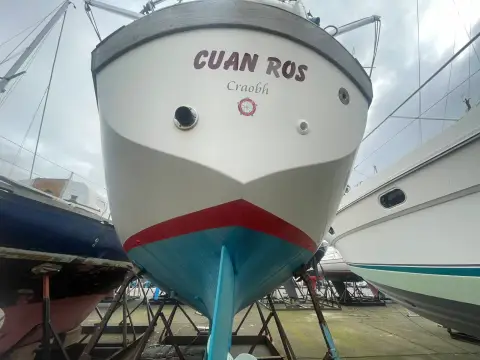 Sovereign 32 Deck Saloon: bow view ashore showing name on hull and red boot top above blue antifouling
