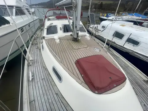 Sovereign 32 Deck Saloon: teak side deck and coachroof with covered forward hatch, looking forward