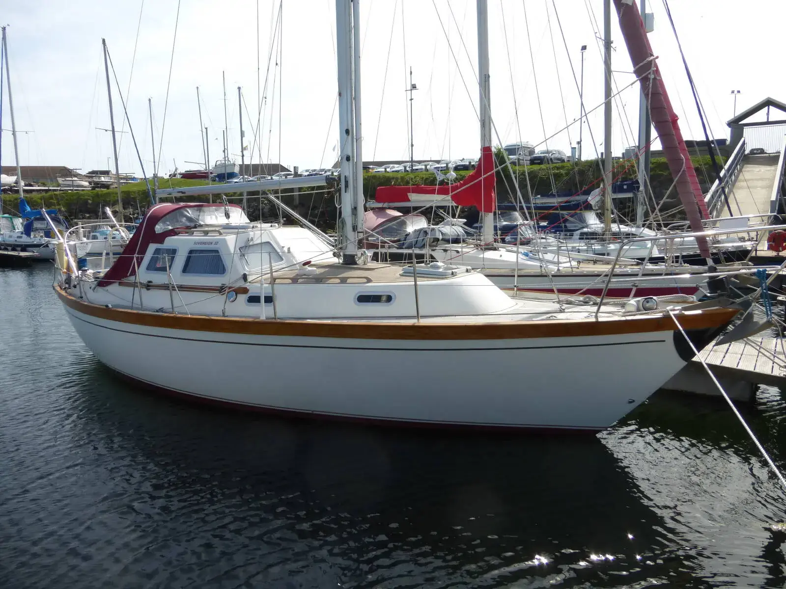 Sovereign 32 Deck Saloon: white hull with gold stripe and raised deck saloon, afloat in a marina berth