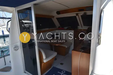 Starfisher 840: sliding glass doors open from cockpit into wheelhouse saloon with dinette and wooden table