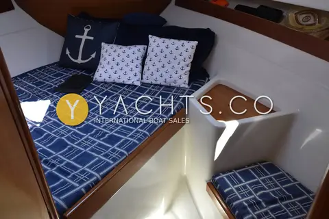 Starfisher 840: forward cabin V-berth with blue checked cushions and anchor-pattern pillows