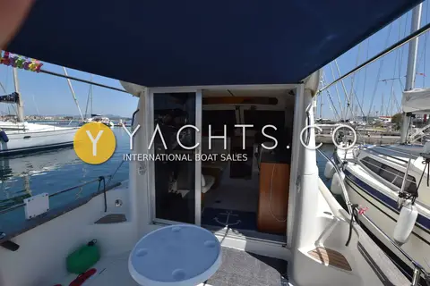 Starfisher 840: cockpit under blue canopy looking through open doors into the wheelhouse, marina behind
