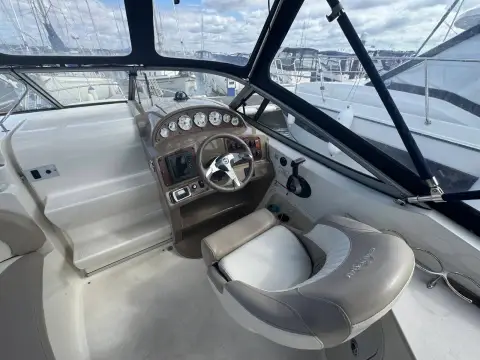 Stingray 250 CS: helm station with wood-effect dash, steering wheel and cream helm seat