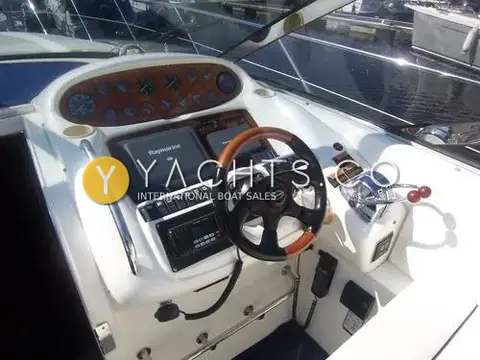 Sunseeker Camargue 47: helm with wood-trimmed wheel, burr wood gauge panel, Raymarine displays and twin throttles