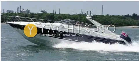 Sunseeker Camargue 47: running at speed on open water, blue hull and white superstructure with ensign