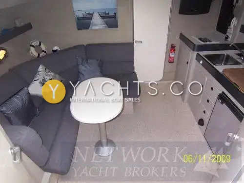 Sunseeker Martinique 36: saloon with grey upholstered corner seating, oval white table and galley units to the right