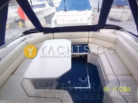 Sunseeker Martinique 36: cockpit with cream U-shaped seating, white table and blue carpet under the blue canopy
