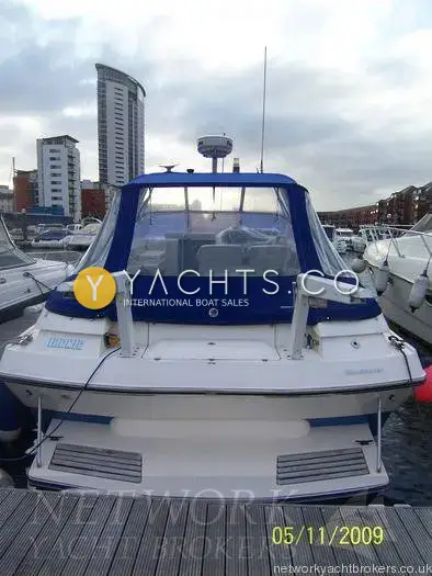 Sunseeker Martinique 36: stern view at the marina berth showing bathing platform, davits, blue canopy and radar dome