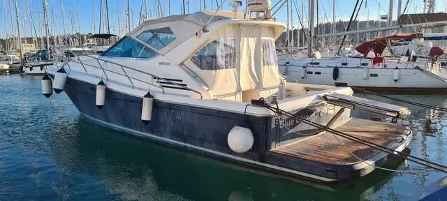 Uniesse 42: dark blue hull and white superstructure moored stern-to with fenders out in a marina