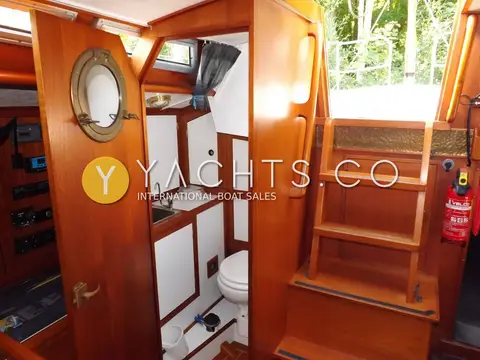 Van Waveren 33 van Waveren: toilet compartment open beside companionway steps, porthole mirror on teak door