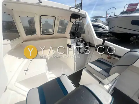Warrior 165: wheelhouse interior with forward berth area, helm wheel and blue-striped seats