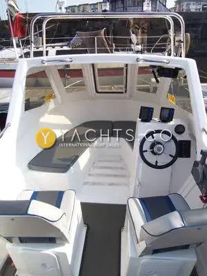Warrior 165: wheelhouse with grey U-shaped seating, starboard helm console and two pedestal seats in front