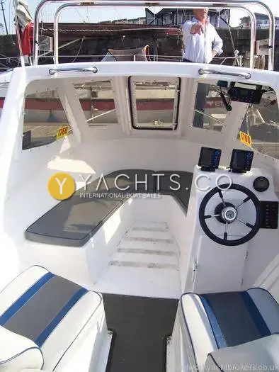 Warrior 165: wheelhouse interior with grey cushioned bench, steps forward and helm with two displays