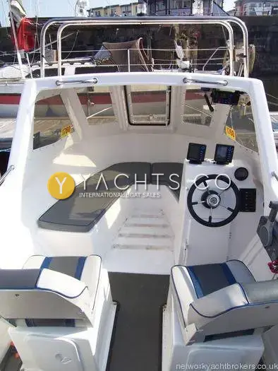 Warrior 165: wheelhouse seen from the cockpit, grey bench seating and helm console with two screens