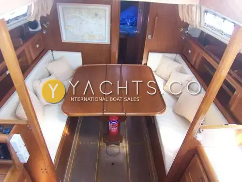 Westerly Fulmar 33: saloon looking forward, cream bench seating either side of a folding wooden table