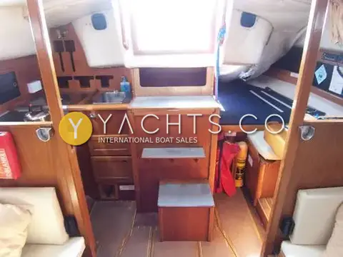 Westerly Fulmar 33: companionway steps with galley to port and quarter berth with blue cushion to starboard