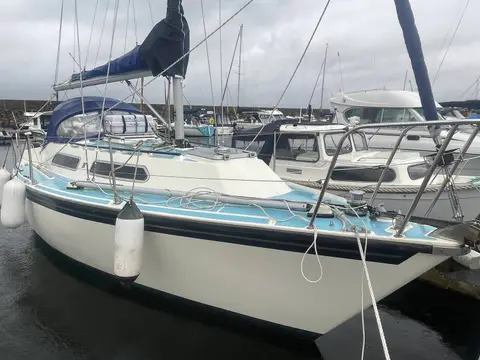 Westerly Merlin 28: starboard bow view moored in marina, white hull with blue deck and fenders