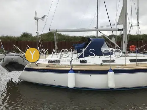 Westerly Oceanquest 35 CC: starboard side of the white hull with navy stripe, sprayhood and wind generator, moored alongside