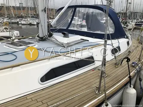 Westerly Oceanquest 35 CC: port side deck with teak decking, coachroof window and navy sprayhood in a marina