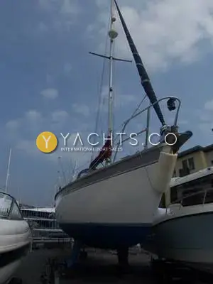 Westerly Tempest: hull ashore on stands seen from the bow, blue antifouling and mast stepped