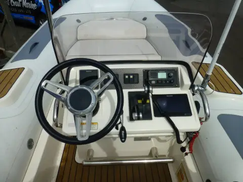 Williams DieselJet 505: helm console with steering wheel, plotter, VHF radio and throttle beneath the windscreen