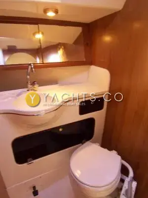 Winner 9.50: heads compartment with moulded sink, mirror, manual toilet and teak-veneered bulkhead