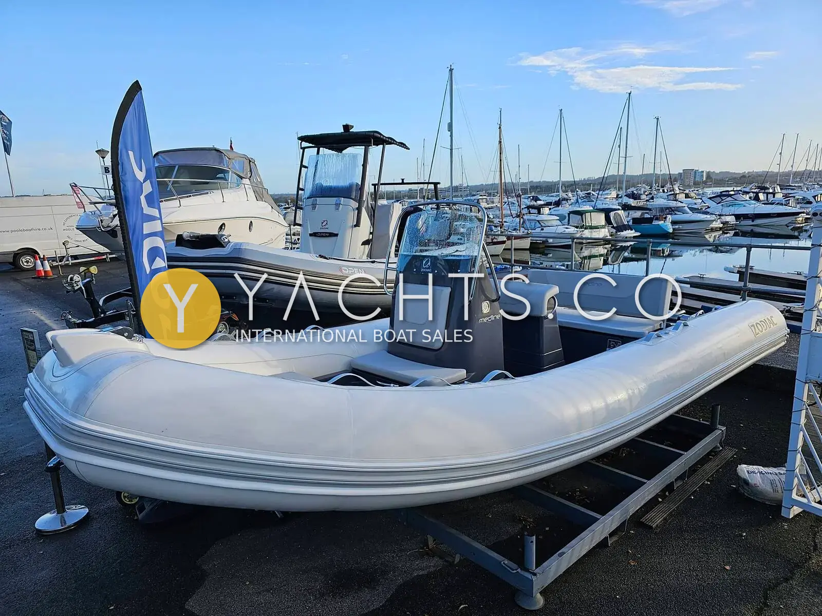 Zodiac Medline 580: grey and white RIB on a trailer stand in a marina boatyard under blue sky