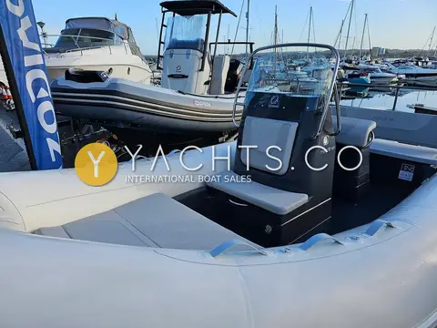 Zodiac Medline 580: helm console with windscreen and grey seat cushion, marina moorings in the background